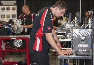 Top: 2013 USTGP champion Jeff Eckman of Yamaha-Honda East in Maumee, Ohio, works on the “No Start — 2013 Super Ténéré” test, while in the background, second-place finisher David Speeks of Houston Motorsports tackles the “Head Gasket Replacement — 2013 YZ450F” test.