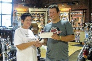 Chaz Cole, general manager of Cole Harley-Davidson in Bluefield, W. Va., presents a check for $485.76 to the local spay association.