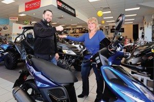 Belinda Phillips looks ready to take over the keys to her KYMCO Super 8 50 2T scooter from GM Nate Stickney of DeLand Motorsports. Phillips won the scooter as part of AIMExpo’s 3-Way Giveaway contest. OEM exhibitors KYMCO, Suzuki and Yamaha Star provided the prizes, which also included a Suzuki Boulevard C90T B.O.S.S. and a customized Star Bolt featuring Kenny Roberts replica graphics.
